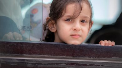 طفلة مسافرة تطل من إحدى حافلات نقل المسافرين في معبر باب الهوى - سورية